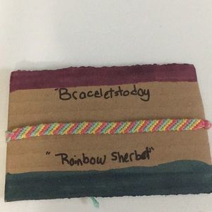 A striped styled bracelet made of cotton thread.